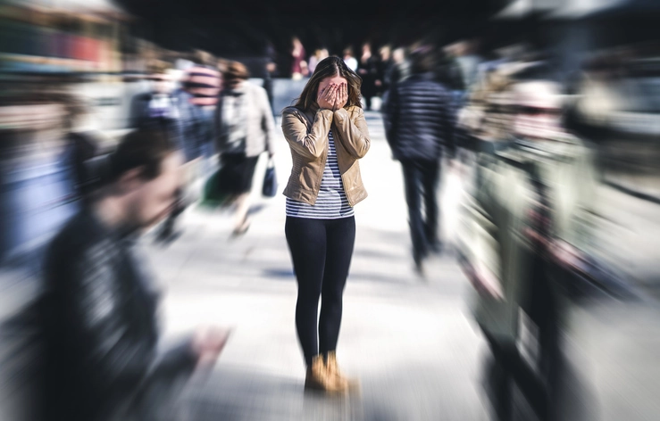 A woman is overwhelmed by anxiety in a busy, public center