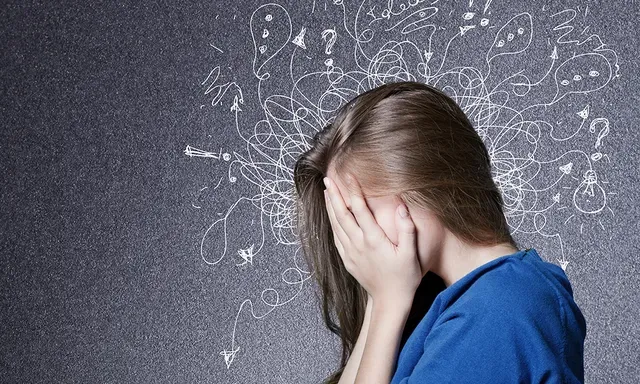 A woman covers her face as she is overwhelmed by anxiety
